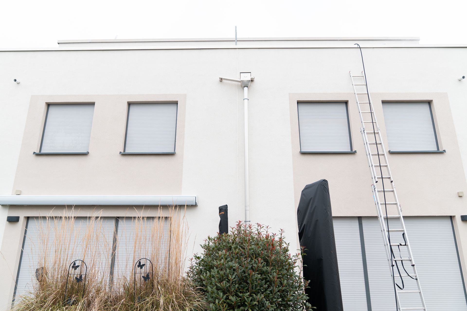 Fertig gereinigte Hausfassade mit angelehnter Leiter am Ende des Arbeitstags.
