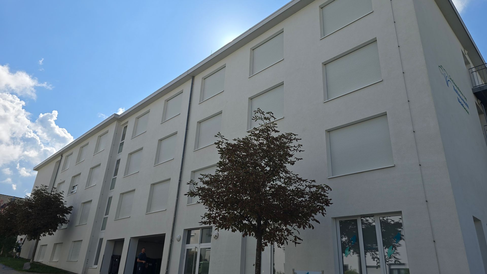 Langgestrecktes Wohngebäude nach der Fassadenreinigung mit gleichmäßig heller Oberfläche.