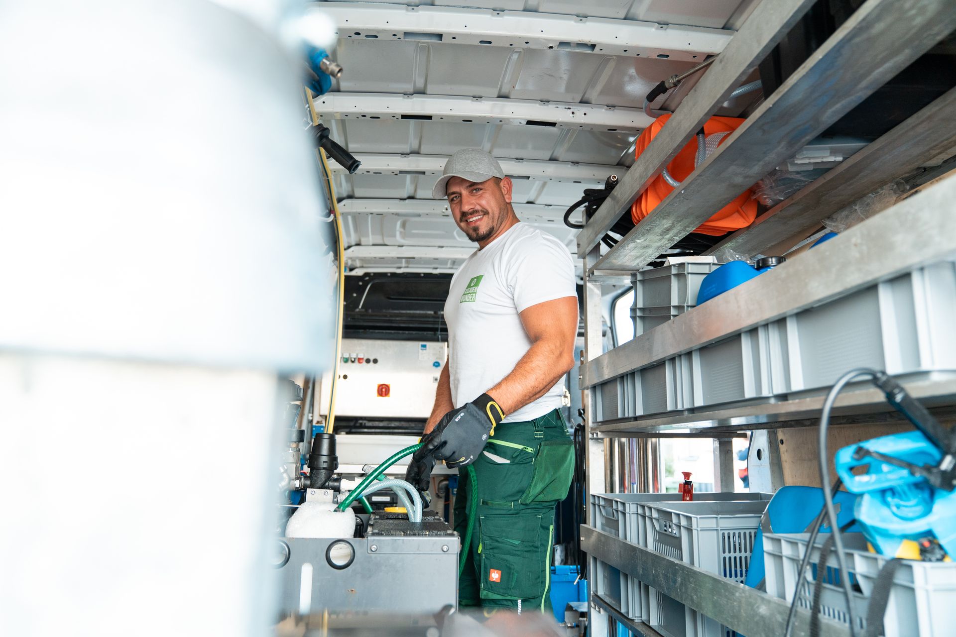 Blick in den ausgebauten Firmenbus mit Reinigungsmaschine, Leitern und Zubehör.